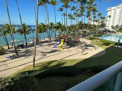 a resort with a playground and a pool and palm trees at Juan Dolio Beach, Marbella Ocean Front in Colorado