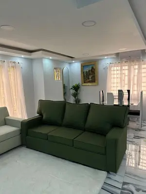 a living room with a green couch and a table at Apartamento Oasis in La Caleta