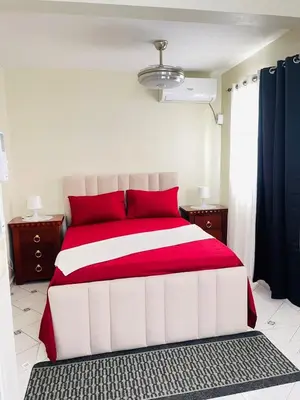 a bedroom with a red and white bed with red pillows at De pina apartaestudio in Santiago de los Caballeros