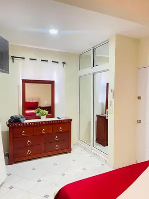 a bathroom with a red dresser and a mirror at De pina apartaestudio in Santiago de los Caballeros