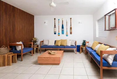 a living room with blue couches and baseball bats on the wall at Oceanfront apartment in Las Terrenas
