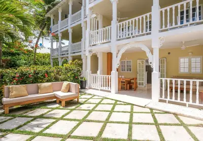 a large white house with a couch on a patio at Oceanfront apartment in Las Terrenas