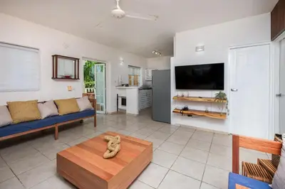 a living room with a couch and a tv at Oceanfront apartment in Las Terrenas