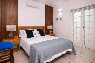 a bedroom with a bed and a blue chair at Oceanfront apartment in Las Terrenas