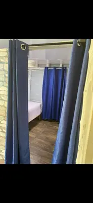 a pair of blue curtains in a room with a bed at La paz y tranquilidad