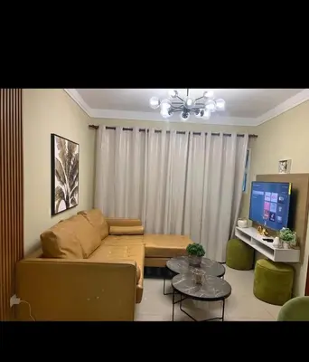 a living room with a couch and a tv at Leni's Confort in Santiago de los Caballeros