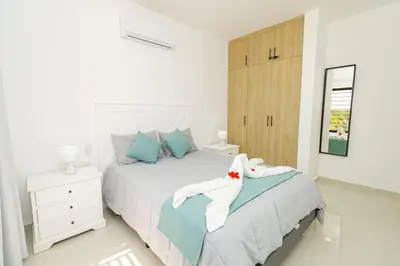 a white bedroom with a bed with towels on it at Tranquil 2BR Retreat in Sunshine Bayahibe in San Rafael del Yuma