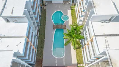 an overhead view of a swimming pool between two buildings at Tranquil 2BR Retreat in Sunshine Bayahibe in San Rafael del Yuma
