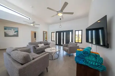 a living room with couches and a flat screen tv at Location , Vibe , Style in Sosúa