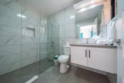 a bathroom with a toilet and a sink and a shower at Location , Vibe , Style in Sosúa