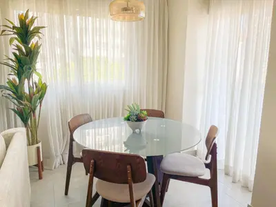 a dining room with a glass table and chairs at Apartamento céntrico 1BR Piantini in Santo Domingo