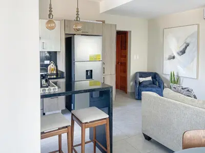 a kitchen and living room with a couch and a table at Apartamento céntrico 1BR Piantini in Santo Domingo