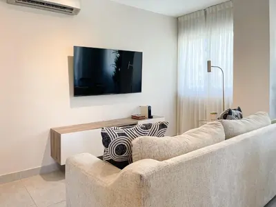 a living room with a couch and a flat screen tv at Apartamento céntrico 1BR Piantini in Santo Domingo