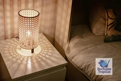 a lamp sitting on a table next to a bed at 3 Bdr Apt in La Romana - Full Kitchen - Pool - Gym - Security in Cumayasa Kilómetros Diez