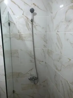 a shower in a bathroom with white marble tiles at Apartamento de lujo amueblado Guadeca B in Juan López