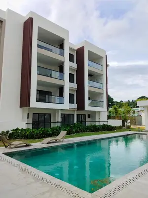 a building with a swimming pool in front of a building at Prado Suites Las Terrenas in Las Terrenas