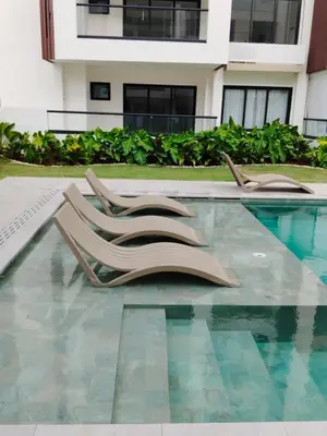 two lounge chairs sitting next to a swimming pool at Prado Suites Las Terrenas in Las Terrenas