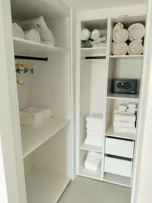 a white closet with white shelves and towels at Prado Suites Las Terrenas in Las Terrenas