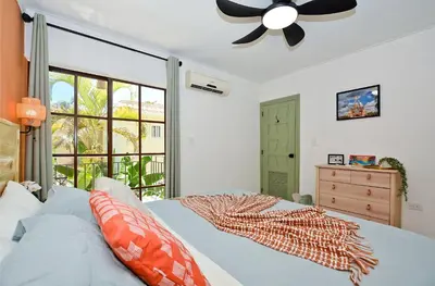 a bedroom with a bed and a ceiling fan at Tropical Retreat in El Cortecito beach condo in Punta Cana