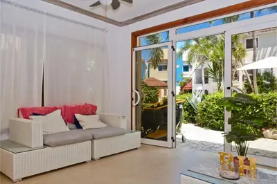 a living room with a couch and a sliding glass door at Tropical Retreat in El Cortecito beach condo in Punta Cana