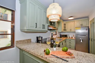 a kitchen with a counter top with a bottle of wine at Tropical Retreat in El Cortecito beach condo in Punta Cana
