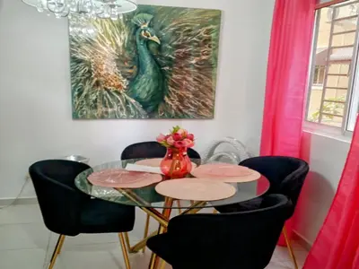 a dining room with a table with chairs and a peacock painting at Prados de la Montana in Bartola