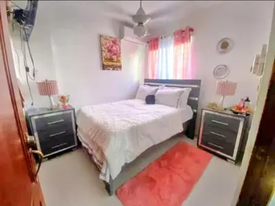 a bedroom with a bed with two night stands and a red rug at Prados de la Montana in Bartola