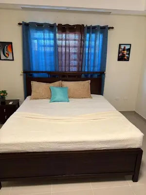 a bed in a bedroom with a blue window at Luxury Apartment in San Pedro de Macorís