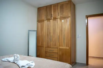 a bedroom with a bed and a wooden cabinet at Luxury Apartment in San Pedro de Macorís