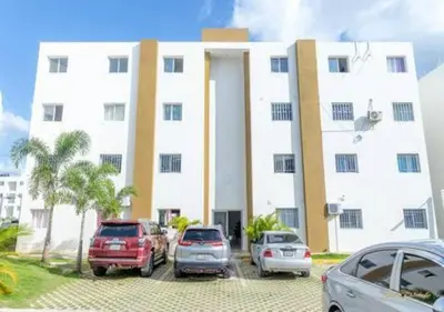 a white building with cars parked in front of it at Next to Basilica 3BR terrace wifi Punta Cana 30min in Higuey
