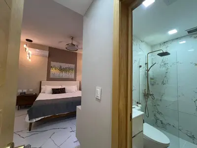 a bedroom with a bed and a bathroom with a shower at Santana Building in San Pedro de Macorís