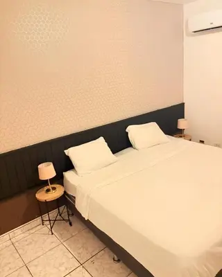 a bedroom with two beds and two tables and two lamps at Colina Buena Vista VIP in Jarabacoa