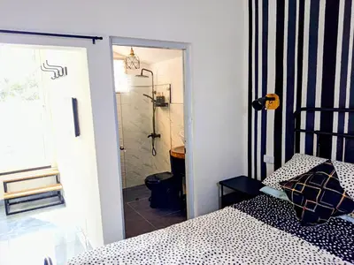 a bedroom with a shower and a bed and a door at Italiana Hogares in Boca Chica