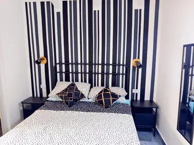 a bedroom with a black and white bed with pillows at Italiana Hogares in Boca Chica