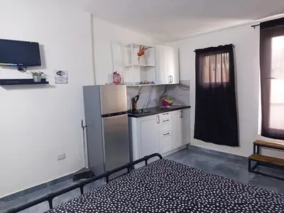a kitchen with a refrigerator and white cabinets and a window at Italiana Hogares in Boca Chica