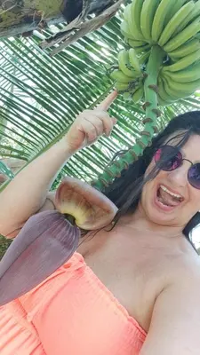 a woman wearing sunglasses holding a bunch of bananas at Unique and quiet TROPICKÝ PRÁZDNINOVÝ DŮM in Punta Cana