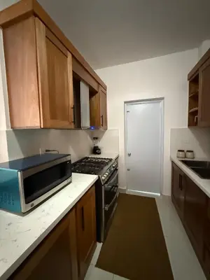 a small kitchen with a stove and a microwave at Brand New Condo-Sunrise in Puerto Plata