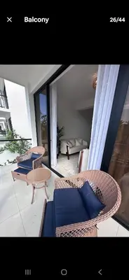 a living room with two chairs and a table at Brand New Condo-Sunrise in Puerto Plata