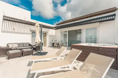 a patio with chairs and a tub and a couch at Penthouse with jacuzzi in Lake View in Las Terrenas