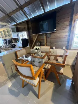 a dining room with a table and chairs and a television at La casa de jasinta in San Felipe de Puerto Plata