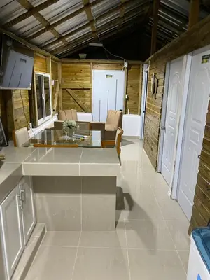a kitchen with a counter and a living room at La casa de jasinta in San Felipe de Puerto Plata