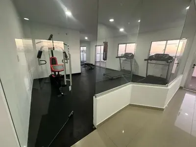 a gym with a red chair in a room at Urban oasis,3 beds, Elevator, Near the airport in Juan López