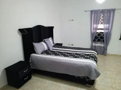 a bedroom with a bed with a black headboard at Home away from home in Guayacanes