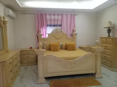 a bedroom with a large bed and pink curtains at Home away from home in Guayacanes