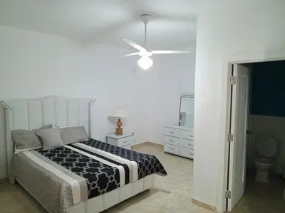 a bedroom with a bed and a ceiling fan at Home away from home in Guayacanes
