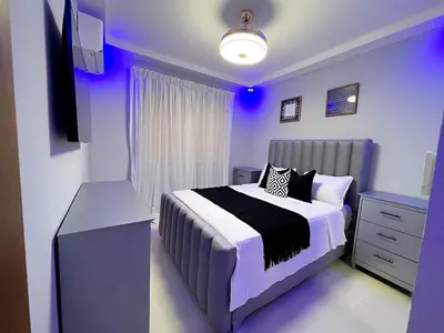a purple bedroom with a bed and a television at Luxury Apartment- PRIVATE Patio & BBQ- Near Airport in Santiago de los Caballeros