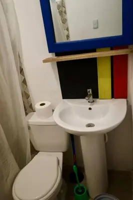 a bathroom with a sink and a toilet and a mirror at Bed-Breakfast lunch Tropical Private-room in Santa Bárbara de Samaná