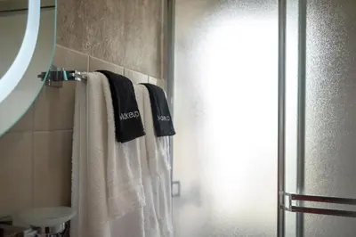 a bathroom with three towels hanging on a towel rack at Studio 3 Zona Colonial - Centro Histórico in Santo Domingo