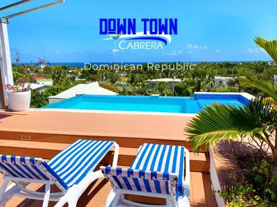 two blue and white chairs sitting next to a swimming pool at Hotel Down Town Cabrera in Cabrera