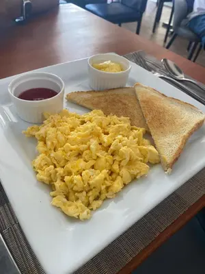 a plate with scrambled eggs and toast and dips at Hotel Down Town Cabrera in Cabrera